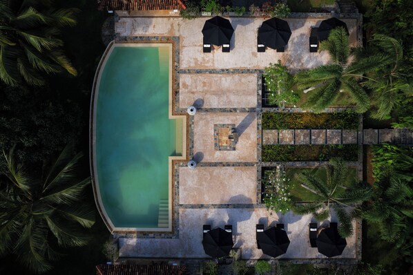 An aerial view of a swimming pool area with lounge chairs and umbrellas, surrounded by palm trees. - JH Villa Estate (Thalpe)