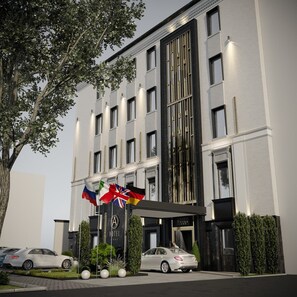 A hotel with a modern facade, multiple windows, and a flag display.