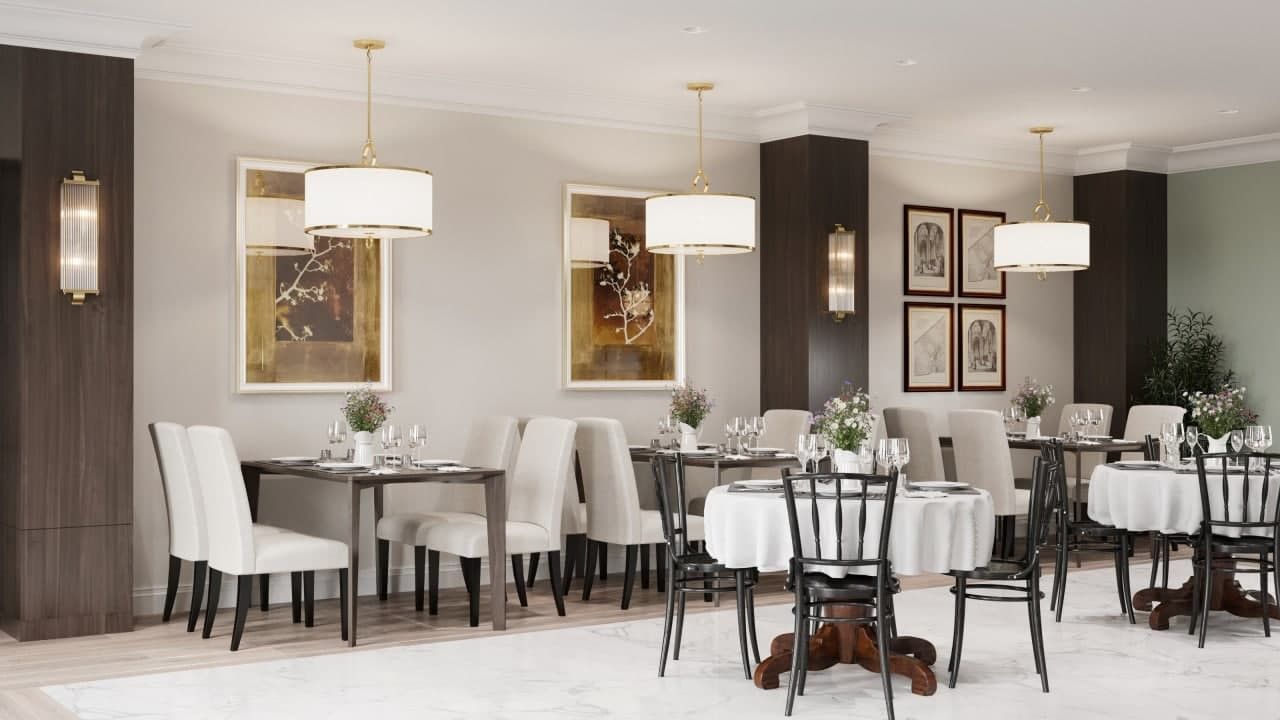 Une salle à manger formelle, dotée de plusieurs tables et chaises, d’un éclairage élégant et d’œuvres d’art encadrées accrochées aux murs.