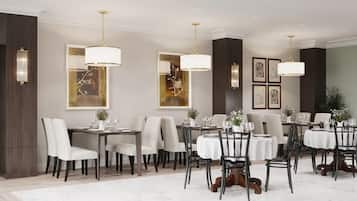 Une salle à manger formelle, dotée de plusieurs tables et chaises, d’un éclairage élégant et d’œuvres d’art encadrées accrochées aux murs.