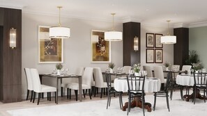 A formal dining area with multiple tables and chairs, elegant lighting fixtures, and framed artwork on the walls.