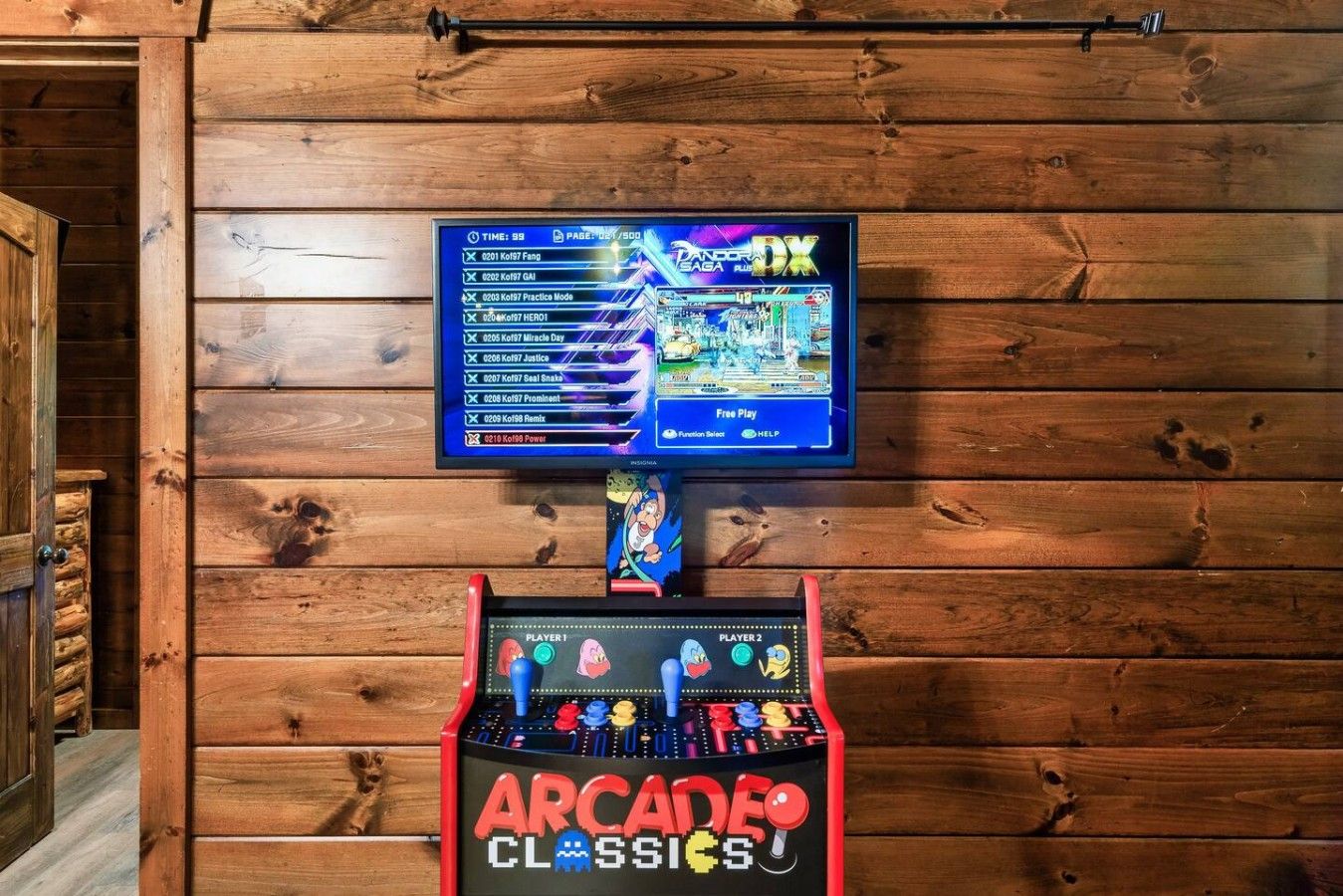 Eine Holzwand mit einem darüber montierten Fernseher und einem Spielautomaten.