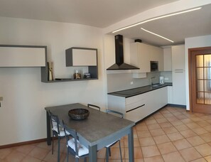 Eine moderne Küche mit Essbereich, ausgestattet mit Backofen, Mikrowelle und einem großen Fenster.