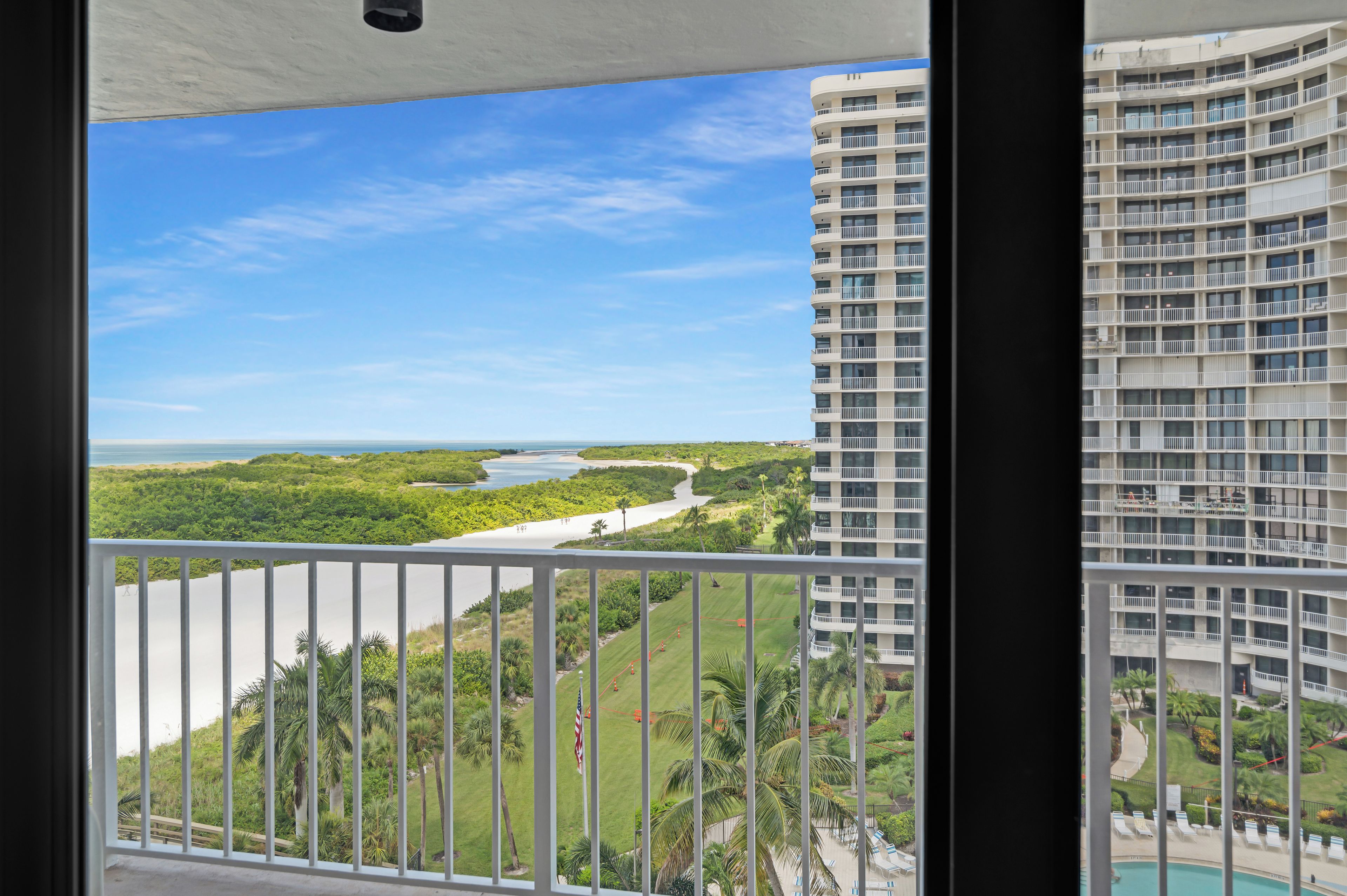 A high-rise building with a view of a river and greenery.