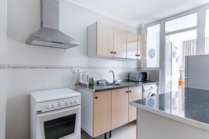 A modern kitchen with white cabinetry, a built-in oven, a microwave, and a coffee maker. - Carabeo 10 by Casasol (Nerja)