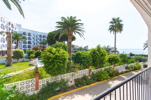 Un hôtel doté d’une piscine, de palmiers et offrant une vue sur la mer.