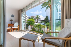 A balcony with two cushioned chairs, a small table, and a lamp. - Carabeo 10 by Casasol (Nerja)