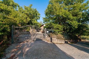 A gated entrance with a gravel path leading to a building, surrounded by trees. - Holiday Home 'Soggiorno dell'artista' with Lake View, Wi-Fi and Air Conditioning (Terni)