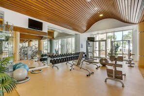 A gym with exercise equipment, mirrors, and large windows. - Updated Luxury Gulf-Front 3BR | Beach Club 1404, Pools, Spa & Beach Chairs (Pensacola Beach)