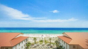 Blick auf einen Strandort mit Strand, blauem Himmel und dem Meer.