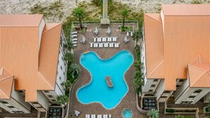 An aerial view of a hotel with a central swimming pool, multiple lounge areas, and a beachside location. - Updated Luxury Gulf-Front 3BR | Beach Club 1404, Pools, Spa & Beach Chairs (Pensacola Beach)