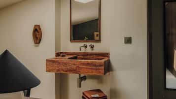 A bathroom with a wooden vanity, a mirror, and a small stool.