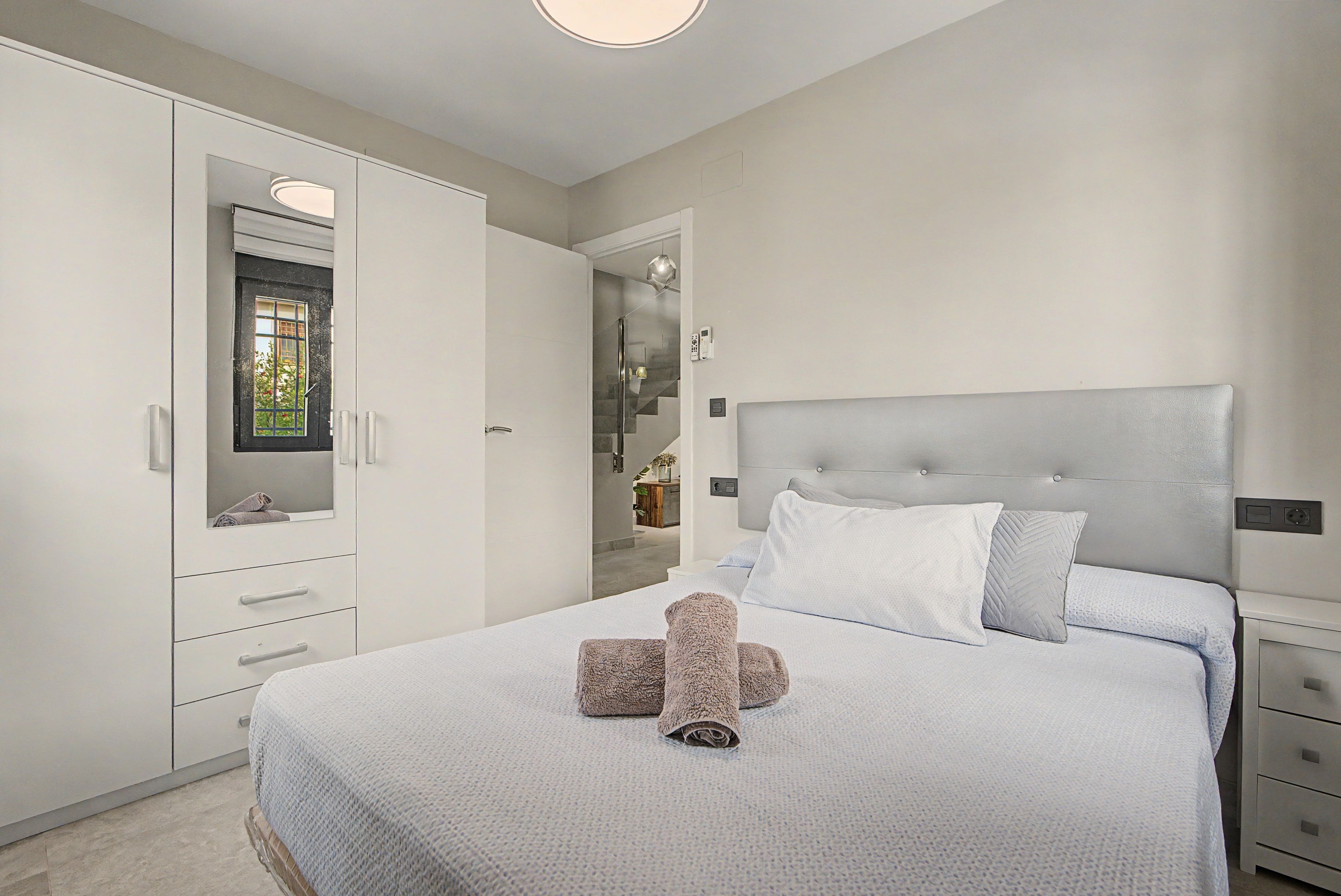 A bedroom with a bed, a wardrobe, and a bathroom visible through an open door.