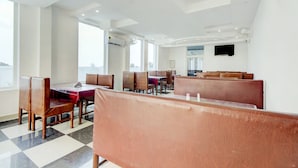 Een restaurant met hoge plafonds, modern meubilair en grote ramen.