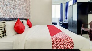 Een hotelkamer met een bed, een bureau, een stoel en een kledingkast.