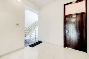 A hallway with a wooden door marked '101' and a staircase leading to an upper level.