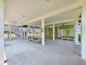 A covered outdoor area with a picnic table and a staircase leading to an upper level. - Mer Sea 4 Bedroom Home (Port Bolivar)