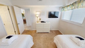 A bedroom with two beds, a dresser, a television, and a window with blinds. - Beach House 601a 2 Bedroom Condo (Miramar Beach)