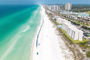 A coastal hotel with a long beachside promenade, multiple high-rise buildings, and a clear view of the ocean. - Beach House 601a 2 Bedroom Condo (Miramar Beach)
