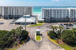 A hotel with multiple floors, a parking lot, and a view of the beach. - Beach House 601a 2 Bedroom Condo (Miramar Beach)