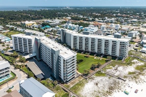 A high-rise hotel with multiple balconies, a central courtyard, and a beach view. - Mainsail 352 3 Bedroom Condo (Miramar Beach)