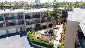 Un hôtel à plusieurs étages doté de balcons, d’un parking et de jardins aménagés avec des palmiers.