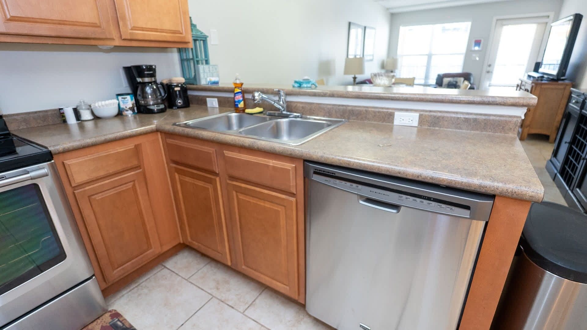 A kitchen with wooden cabinets, a dishwasher, and a coffee maker.