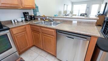 A kitchen with wooden cabinets, a dishwasher, and a coffee maker.