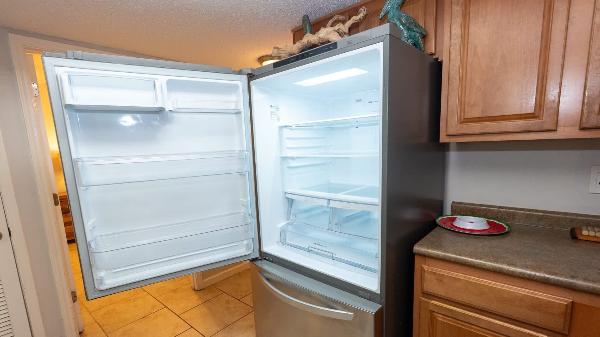 An open refrigerator with multiple shelves and a freezer compartment.