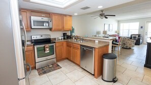 Una cocina moderna con electrodomésticos de acero inoxidable, armarios de madera y una isla central con fregadero.