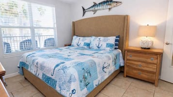 A bedroom with a bed, a nightstand, a lamp, and a wall-mounted fish decoration.