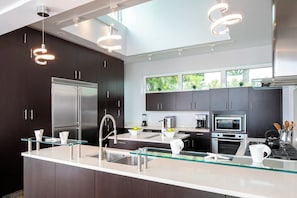 A modern kitchen with stainless steel appliances, a glass island, and pendant lighting. - Casa Mare – Modern 5-Bedroom St. John Villa with Private Pool, Ocean Views & Rooftop Stargazing (cruz bay)