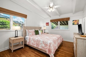 A bedroom with a bed, bedside tables, a ceiling fan, and a window with a view. - Kauai Hoohu Hale 3 Bedroom Home (Koloa)