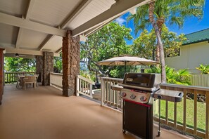 An outdoor patio with a grill, seating area, and a view of the surrounding greenery. - Kauai Hoohu Hale 3 Bedroom Home (Koloa)