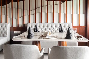 A dining area with a white table set for four, including plates, glasses, and cutlery.