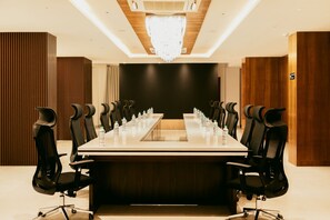 A conference room with a long table, black chairs, and water bottles.