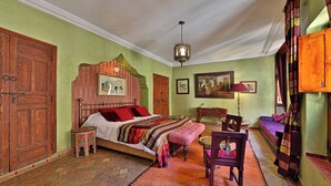 Ein traditionell eingerichtetes Zimmer mit einem großen Bett, einem kleinen Tisch und einem Schlafsofa.