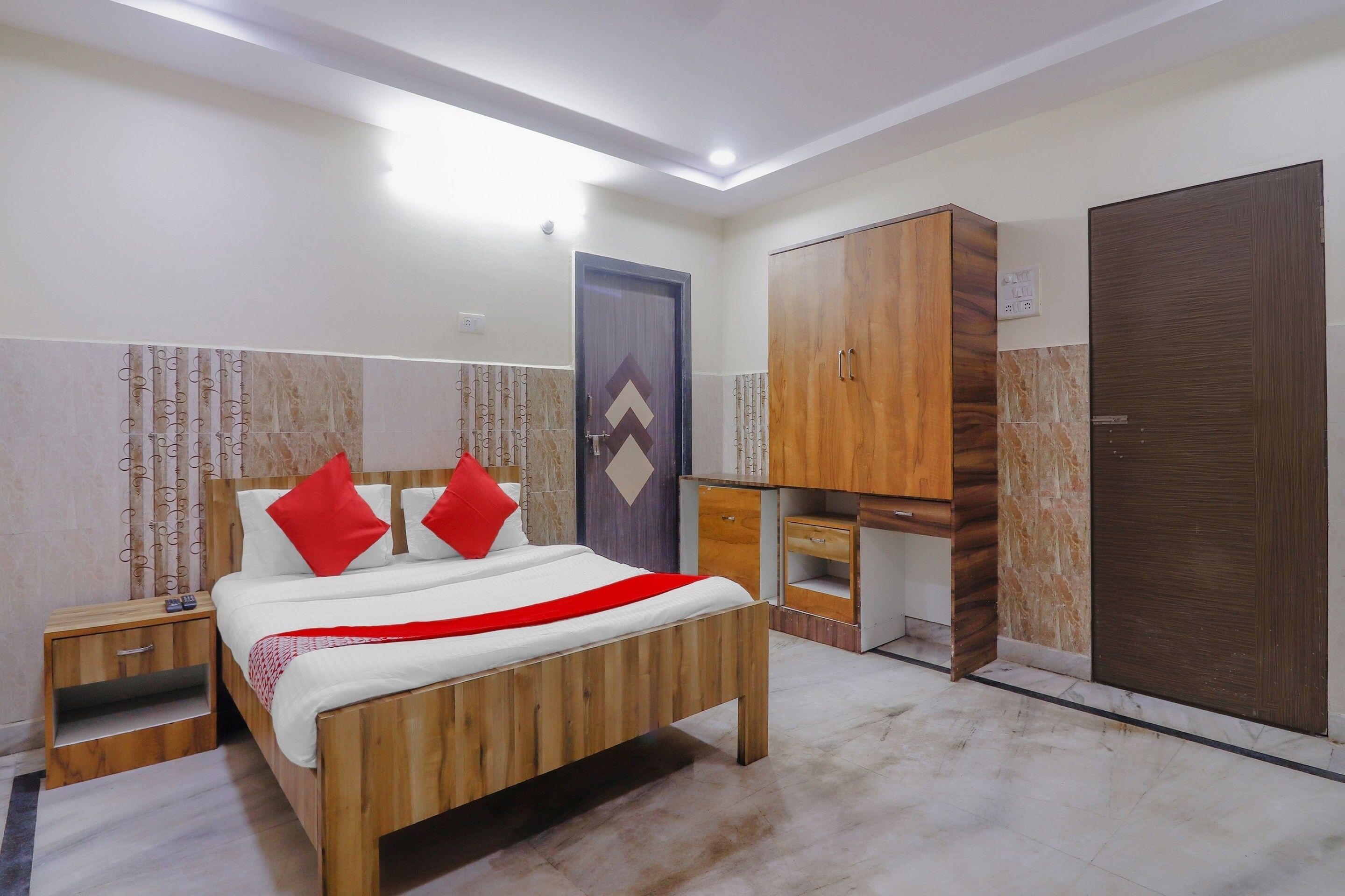 A bedroom with a wooden bed, a wardrobe, a desk, and a wardrobe with a mirror.
