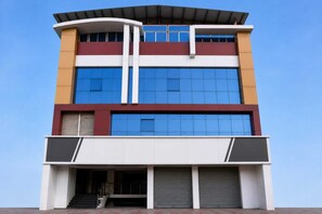 A multi-story building with large windows, a flat roof, and a covered entrance. - Classic Hotel Ashoka Grand (Sadasivpet)