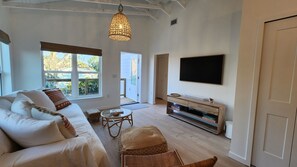 A living room with a sofa, a television, and a coffee table. - 2-Bedroom Nature Lovers Escape (Sanibel)