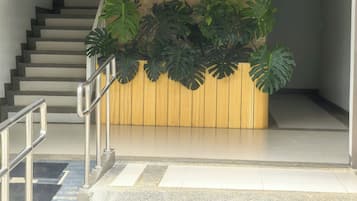 A staircase leading to a reception area with a wooden panel and the word 'DASSIA' on it.