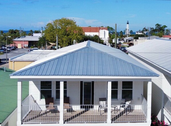 A building with a covered porch and a view of the surrounding area. - Downtown Port St Joe (Port St Joe)