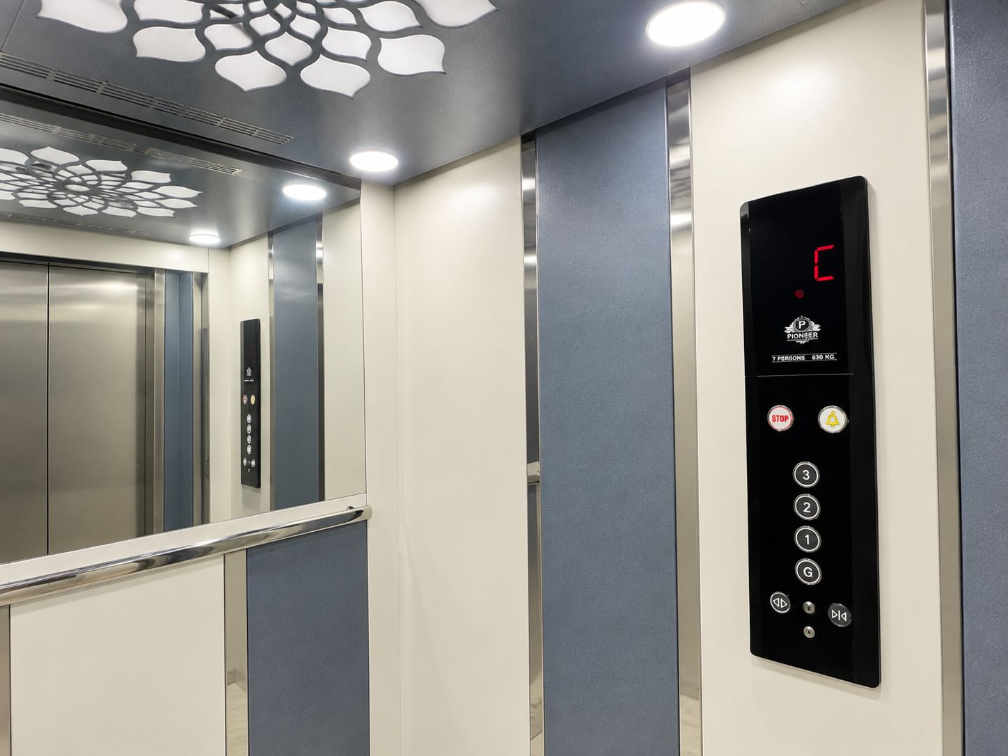 An elevator interior with a digital display, control buttons, and a metallic elevator door.