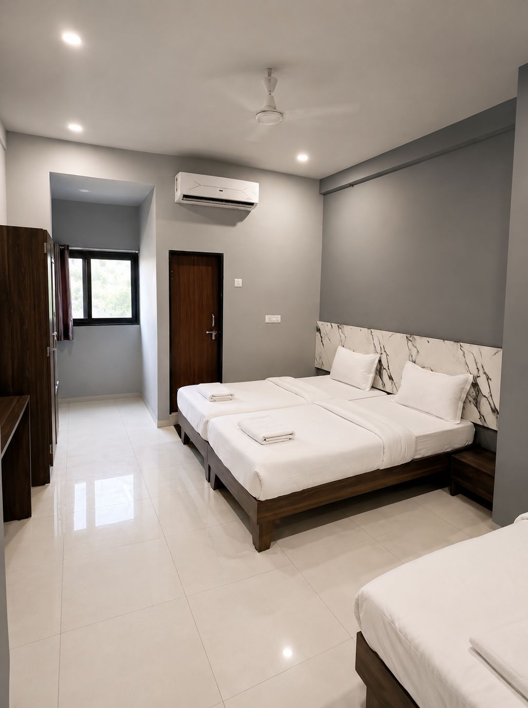 A modern bedroom with a large bed, a wardrobe, and a window.