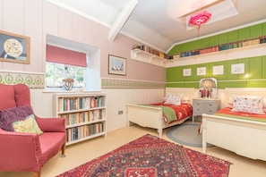 Un dormitorio acogedor con dos camas, una estantería, una silla y una ventana con vistas.
