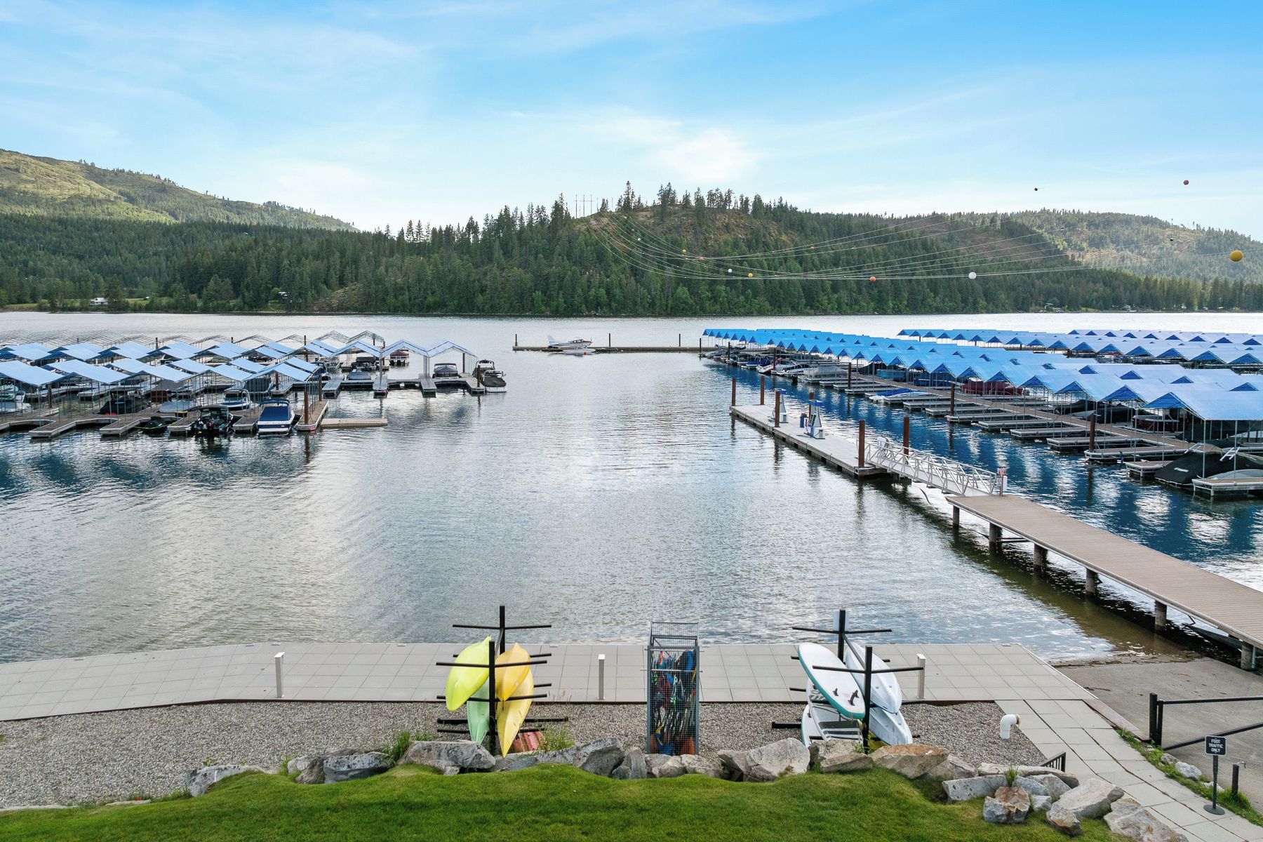 A marina with boats docked, a covered boat house, and a dock with kayaks.