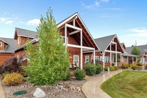 A residential building with a prominent wooden facade, a covered porch, and a well-maintained garden with various shrubs and a small tree. - New! Cottage by the Bay | 3 Min Walk To Dover Bay Marina | Pet Friendly | AC (Dover)