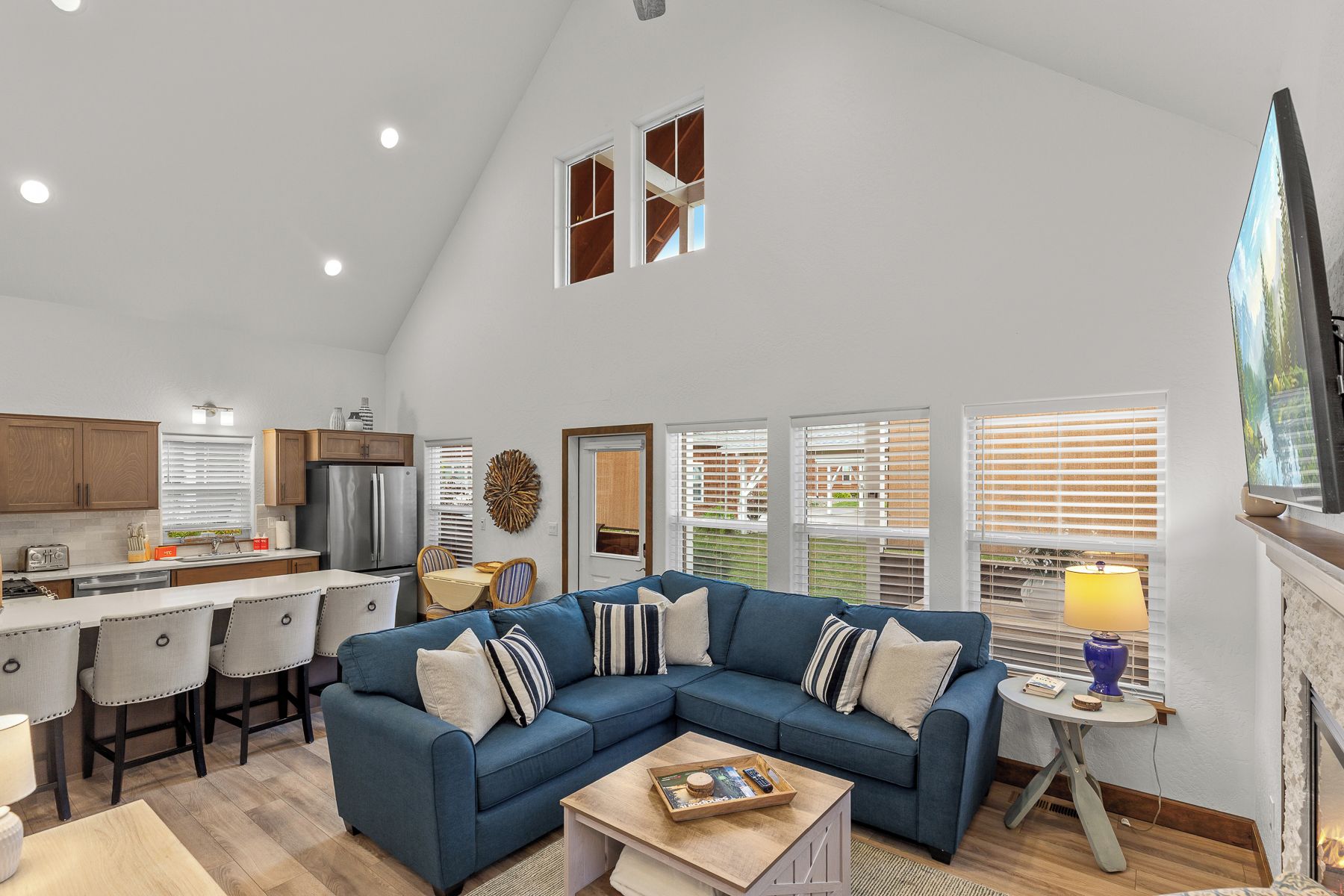 A spacious living room with a sectional sofa, a dining area, and a kitchen.