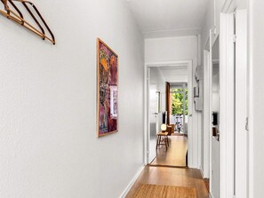 A hallway with a wooden floor, a door leading to another room, and a framed artwork on the wall. - 4 Star Holiday Home in Faaborg (Faaborg)