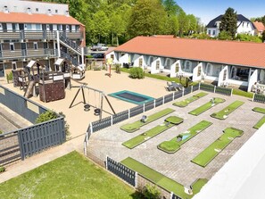 A courtyard with a playground, a swimming pool, and a tennis court. - 4 Star Holiday Home in Faaborg (Faaborg)
